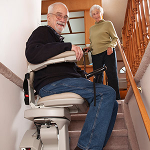 Elderly man sitting on stair life with wife watching from top of stairs